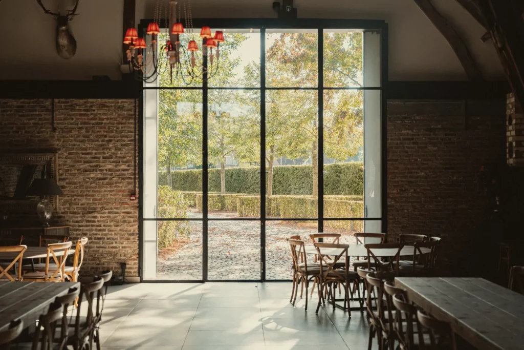 Groot stalen raam in het atelier van Diepenbroekhof met zicht op de tuin