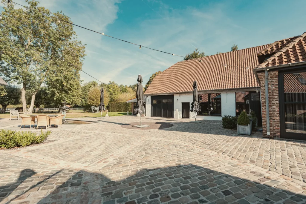 Zonnige binnenplaats van Diepenbroekhof met de witte hoevegebouwen