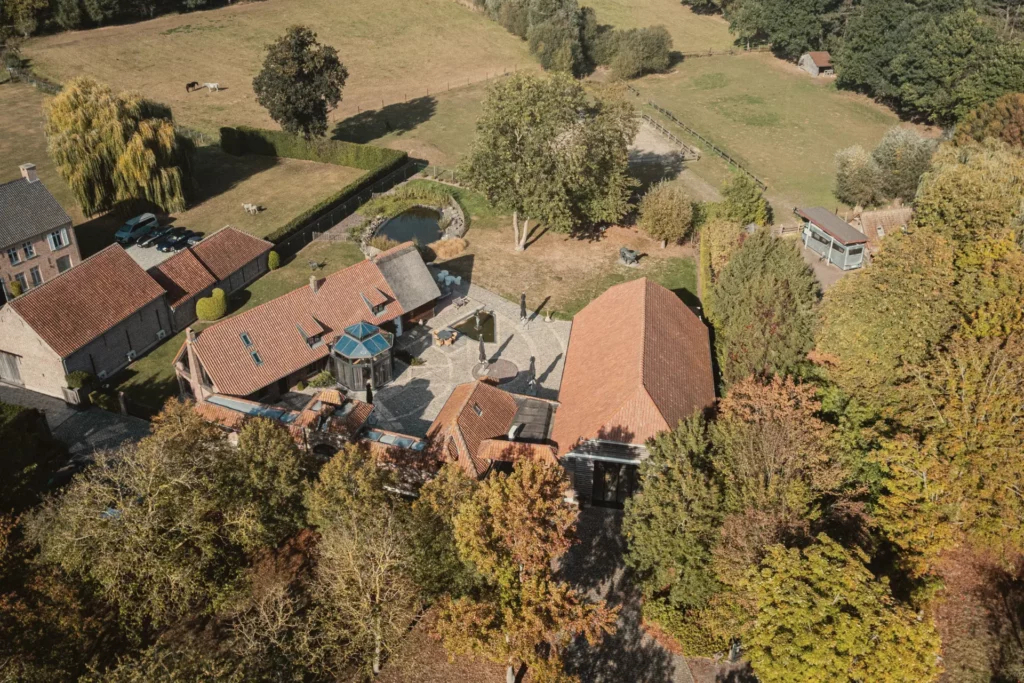 Luchtfoto van het domein Diepenbroekhof tussen de bomen en weides
