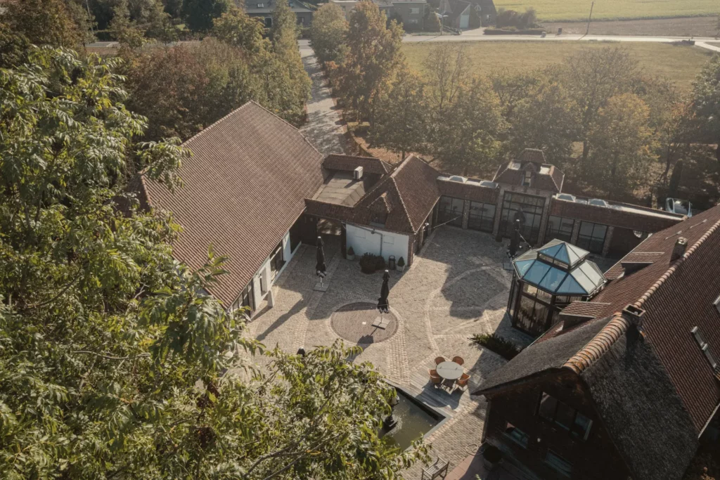 Luchtfoto van de gerestaureerde hoeve Diepenbroekhof in het groen
