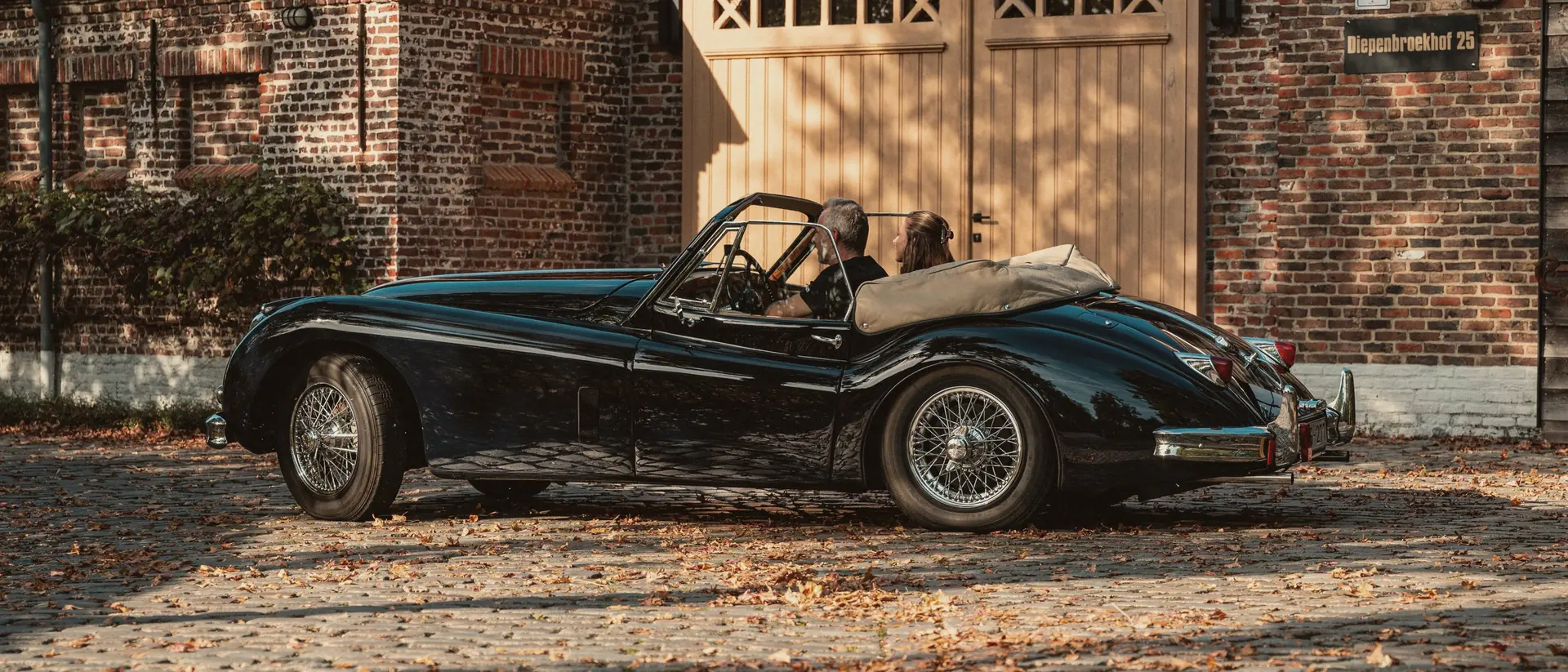 Jaguar XK140 voor de poort van het atelier op Diepenbroekhof