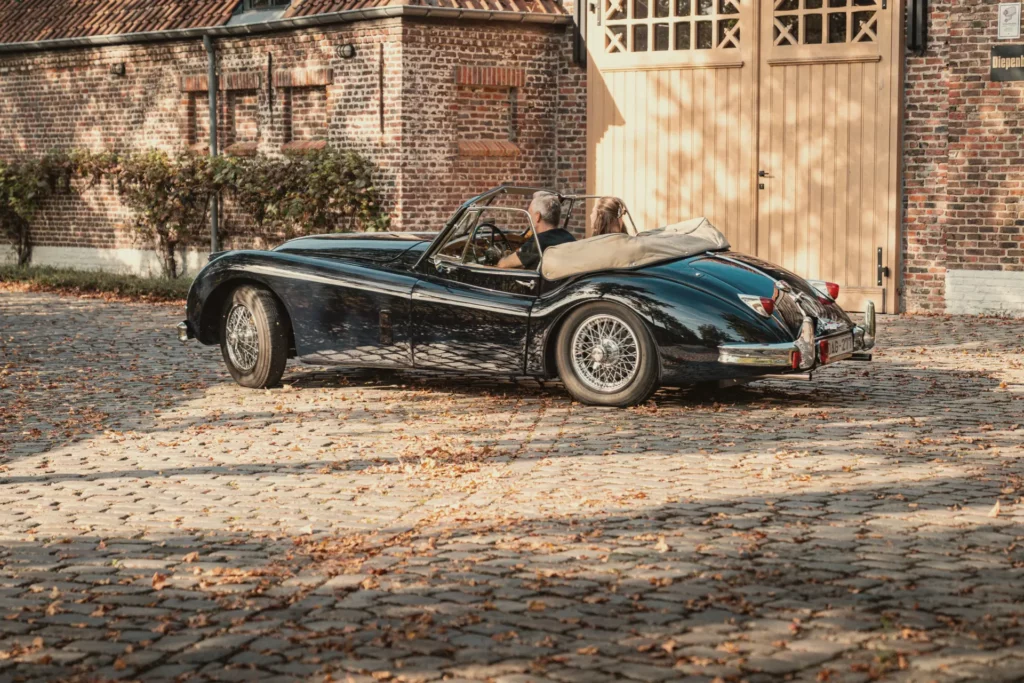 Jaguar XK140 voor de poort van het atelier op Diepenbroekhof