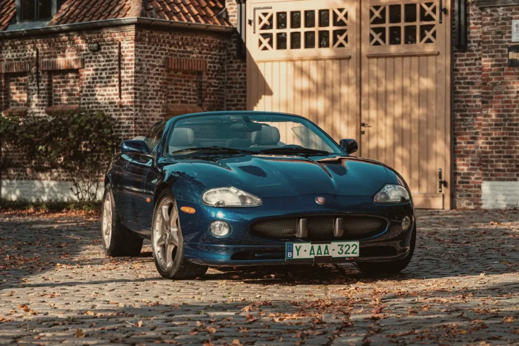 Jaguar XKR cabrio voor de poort van het atelier op Diepenbroekhof